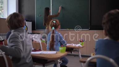 女教师在黑板上写数学方程式