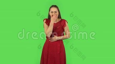 穿着红色衣服的温柔女孩得了感冒，喉咙和头都痛，咳嗽。 绿色屏幕