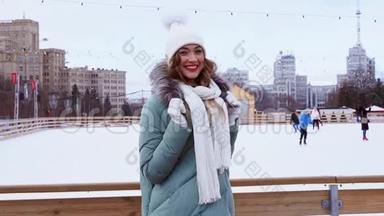 美丽可爱的中年女孩，卷发温暖的冬季夹克站在冰场背景镇广场。