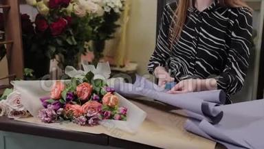 专业的花店正在包装一束花。 为国际妇女节准备`美丽的花束..
