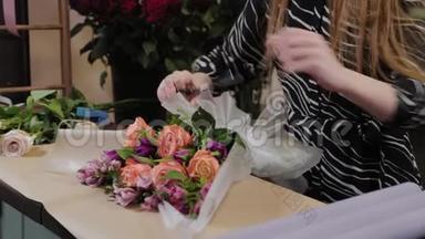 专业的花店正在包装一束花。 为国际<strong>妇女节</strong>准备`美丽的花束..