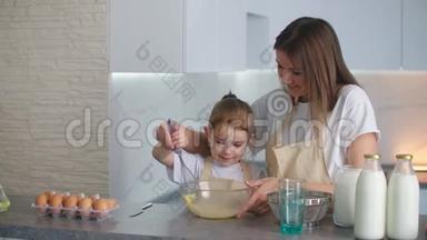 幸福的家庭在厨房里，妈妈和女儿在厨房里玩面粉，玩得开心，在厨房里塑造馅饼
