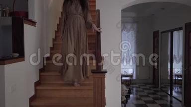神秘的光着脚的白种人女人走下楼梯在室内离开。 穿着<strong>长裙</strong>的鬼魂<strong>画</strong>像