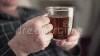 特写男高白种人双手捧茶。 无法辨认的养老金领取者向别人挥手。 生活方式