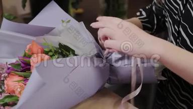 专业的花艺师用绸带系花束. 为国际妇女节准备`美丽的花束..