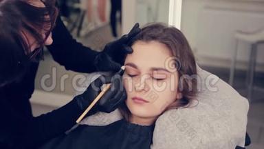 在一家美容院，专业的眉毛师女士给客户画眉毛。