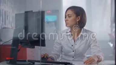 女医生坐在<strong>医院的</strong>桌子旁，用手提电脑打字。 女医生护士