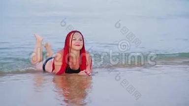 一个穿着红色辫子的黑色泳衣的女人躺在海边的海水里