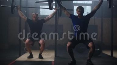 两个强<strong>壮</strong>的<strong>男人</strong>一起在健身房做举重训练。 中档慢动作平底锅男子健身房锻炼