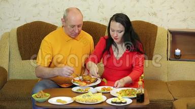 男人和女人在家庭聚餐时吃蔬菜