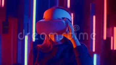 女人戴着VR耳机，从一边到另一边快速倾斜，同时在黑暗的空间里玩，照亮了霓虹灯。