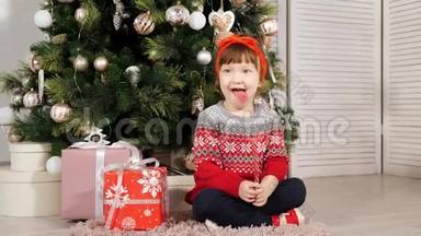 小女孩<strong>坐在</strong>圣诞<strong>树下</strong>笑着拍照
