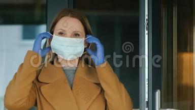 一个女人在房子的出口戴着一个防护面具。流行病期间的保护措施