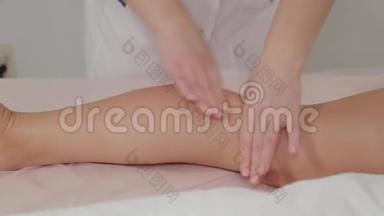 女按摩师在一个年轻女孩的小腿肌肉上做按摩。