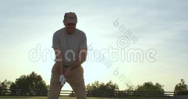 年轻英俊的高尔夫球手，日落时在美丽的球场上挥杆击球。