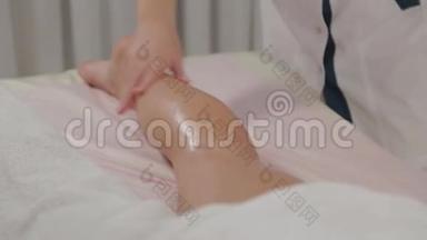 女按摩师在一个年轻女孩的小腿肌肉上做按摩。
