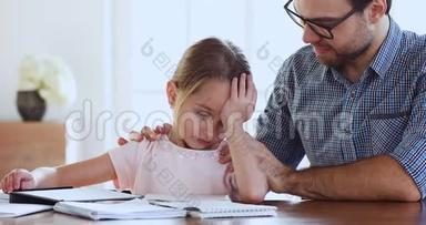 关爱的爸爸支持鼓励悲伤疲惫的女儿一起学习