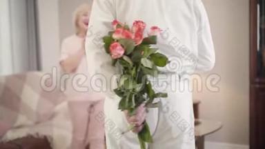 在<strong>圣瓦伦丁节</strong>，优雅成熟的白种人男子向美丽`妻子赠送玫瑰花束。 高级
