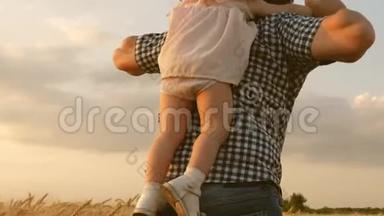 快乐的孩子和父亲正在一片成熟的麦子里玩耍.. 幸福的家庭和童年的概念。 女儿和父亲