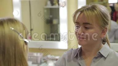 专业化妆师用棉签`客户的脸。