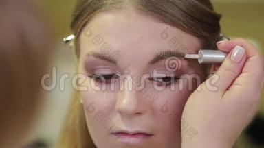 专业化妆师用特殊的画笔向客户<strong>画眉</strong>毛。