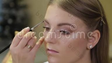 专业化妆师用特殊的画笔向客户<strong>画眉</strong>毛。