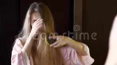 头发干脆的<strong>不开心</strong>的女人在镜子里检查她缠着的头发