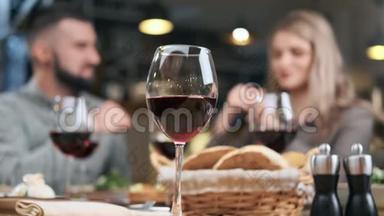 在餐厅的年轻夫妇晚餐时，<strong>把酒</strong>杯放在桌上。 4K红色相机拍摄