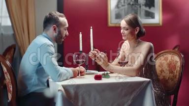 情侣在浪漫的约会中一起笑着看着智能手机屏幕。 红色相机宽镜头