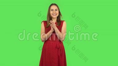 一个穿着红衣服的小女孩高兴地<strong>拍手</strong>叫好。绿色屏幕
