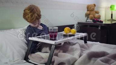 悲伤的白种人红头男孩躺在床上喝着热果茶。 病童卧床的肖像