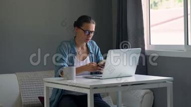 戴眼镜的年轻严肃的女人在电脑里工作。 感觉<strong>很累</strong>。