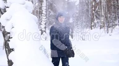 冬天，一个孩子在露天玩耍，扔雪。 积极的户外运动。