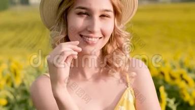 戴着帽子，站在向日葵的田野上，美丽欢快的女孩的特写肖像