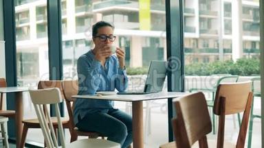 咖啡馆和一个拿着笔记本电脑的女人在喝咖啡