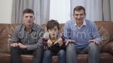高加索多代球迷家庭在电视上观看比赛的肖像。 中年男子，他成年的儿子
