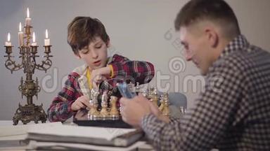 注意力从一个白人小男孩下国际象棋，用智能手机和年轻的父亲聊天开始转变。<strong>起源</strong>