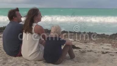 一家人坐在海边，轻轻地拥抱着对方