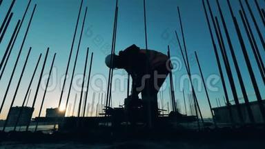 专业工程师在日落背景下的建筑工地上工作。