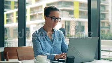 漂亮的女士在咖啡馆里操作笔记本电脑