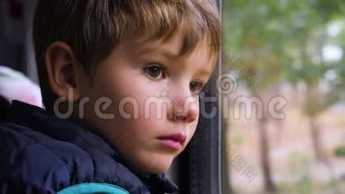 可怜的年轻乘客。 一个好奇的小男孩在火车上向窗外看的特写镜头。 面部表情。 坏坏坏坏