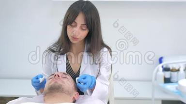 美容师用人造手套擦拭人脸`保湿面膜。