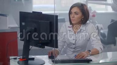女医生<strong>坐在</strong>办公桌<strong>前</strong>用笔记本<strong>电脑</strong>工作。