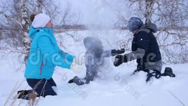 妈妈和孩子们互相扔雪，在冬天的公园里尽情享受。 冬天在公园散步。 他的笑声和欢乐