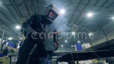 焊接操作人员在一个车间用铁工作。 在工厂设施工作的专业焊工。