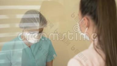 接待处的病人在医院。 戴防护手套和医用口罩的护士告知患者..