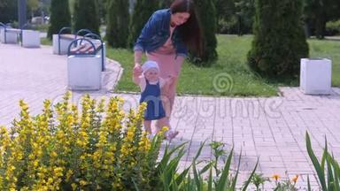 妈妈正和女儿在公园散步，宝贝女儿牵着她的手学习去。