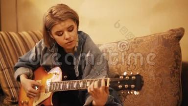 女孩弹吉他，在<strong>沙</strong>发上唱歌。 女人在室内创作<strong>音乐</strong>。 艺术家在吉他上表演。 一位<strong>音乐</strong>家