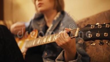女孩弹吉他，在<strong>沙</strong>发上唱歌。 女人在室内创作<strong>音乐</strong>。 艺术家在吉他上表演。 一位<strong>音乐</strong>家