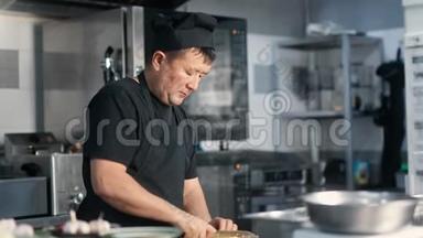亚洲男厨师在餐厅厨房准备食物切割配料。 中型摄影机